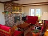 Living room features propane fireplace and exposed wood beams